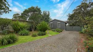 a house with a garden and a gravel driveway at Burrangarra in Callala Beach