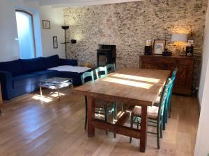 ein Wohnzimmer mit einem Holztisch und einem blauen Sofa in der Unterkunft Maison Locmaria, 4 pièces, 6 personnes - FR-1-418-245 in Locmaria