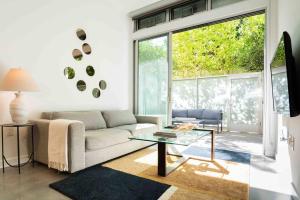 a living room with a couch and a glass table at Fiera WeHo residence in Los Angeles