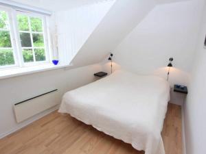 um quarto branco com uma cama e uma janela em 6 person holiday home in Svaneke em Svaneke