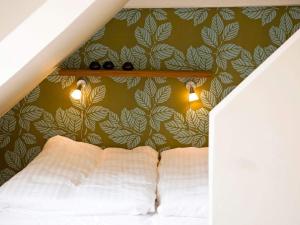 a bedroom with a bed with a green wall at 3 person holiday home in Svaneke in Svaneke