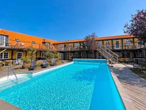 a swimming pool in front of a building at 3 person holiday home in Svaneke in Svaneke