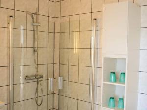 ein Bad mit einer Dusche und einer Glastür in der Unterkunft 4 person holiday home in Svaneke in Svaneke