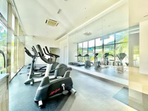 a gym with treadmills and ellipticals in a room at By The Sea Penang in Batu Ferringhi