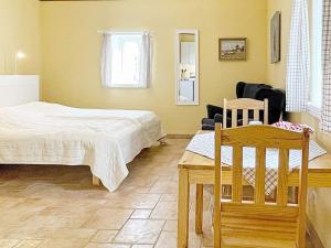 een slaapkamer met een bed en een tafel en stoelen bij 3 person holiday home in SKIVARP in Skivarp