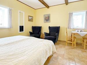 een slaapkamer met een bed en 2 stoelen en een tafel bij 3 person holiday home in SKIVARP in Skivarp