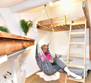 a girl sitting in a hammock in a room with bunk beds at SURF HOSTEL BIARRITZ in Biarritz