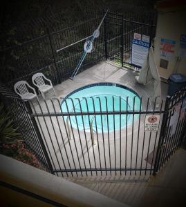 a cage with a swimming pool with chairs in it at Pacific Plaza Resort in Oceano