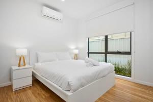 Braybrook的住宿－Contemporary Urban Escape Braybrook，白色的卧室设有白色的床和窗户。