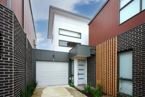 Braybrook的住宿－Contemporary Urban Escape Braybrook，红白色房子,带两个车库门