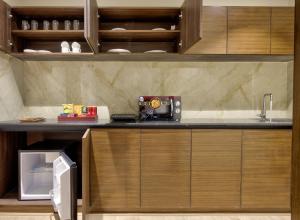 a kitchen with wooden cabinets and a counter top at Lance 21 - Ashok Nagar in Chennai