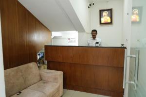 a man standing behind a bar in a room at AIRPORT COCHIN ROYAL RESIDENCY in Ernakulam