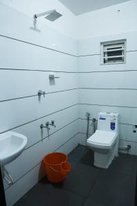 a bathroom with a white toilet and a sink at AIRPORT COCHIN ROYAL RESIDENCY in Ernakulam