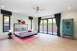 Un dormitorio con una cama y un ventilador de techo. en Brand-new 8BR Private Pool Villa Mystic Garden, en Rawai Beach
