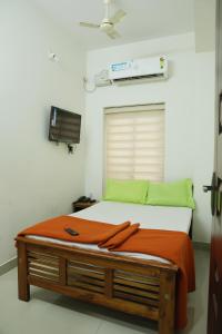 a bed in a room with avertisementatronatronstrationstrationstrationstration at AIRPORT COCHIN ROYAL RESIDENCY in Ernakulam