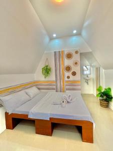 a bedroom with a large bed with a table at Villa Lovi Panagsama Beach Moalboal in Moalboal