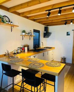 a kitchen with a large wooden counter top with chairs at Villa La Altragracia in Constanza