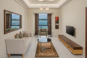 a living room with a couch and a tv at Element by Westin Hotel Dar es Salaam in Dar es Salaam