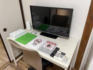 uma secretária com um monitor de computador em cima de uma mesa em TSUBAME 101 staying private home em Osaka