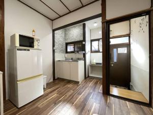 TSUBAME 101 staying private home في أوساكا: مطبخ مع ثلاجة ومغسلة