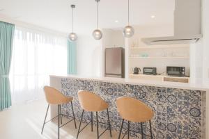 a kitchen with three chairs and a counter top at アイニクル -Create Future Community- in Ishigaki Island