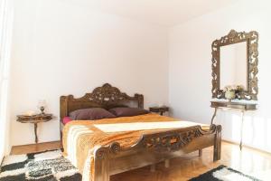 Schlafzimmer mit einem Holzbett und einem Spiegel in der Unterkunft Holiday home Villa More - 10m from sea in Rogoznica