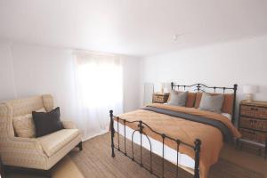 a bedroom with a bed and a chair at Maisie's Robe - Dog Friendly - Wi-Fi in Robe