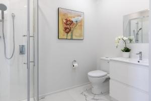 biała łazienka z toaletą i prysznicem w obiekcie Oasis Rural Retreat w mieście Norsewood
