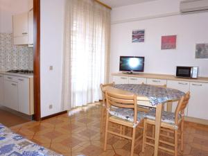 a kitchen with a table and chairs in a room at Cosy apartment with balcony in Porto Santa Margherita di Caorle