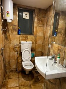 een badkamer met een toilet en een wastafel bij Jash hospitality in Surat