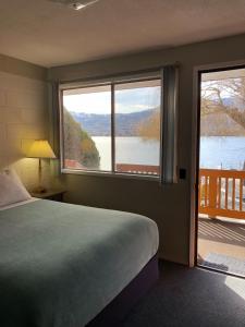 a bedroom with a bed and a view of a lake at Sun Beach Motel in Osoyoos