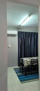 a room with a table in front of a curtain at RizqFateh Homestay in Kluang