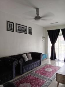 a living room with a black couch and a window at RizqFateh Homestay in Kluang