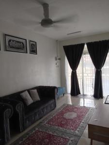 ein Wohnzimmer mit einem Sofa und einem großen Fenster in der Unterkunft RizqFateh Homestay in Keluang