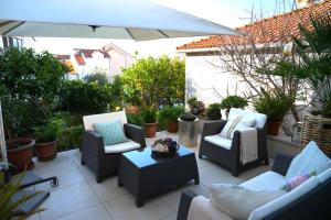 a patio with chairs and a table and an umbrella at Apartments Apartmani Oh La La - terrace in Supetar