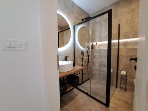 uma casa de banho com um lavatório e um espelho em Apartment Jere - modern and near the sea em Brodarica