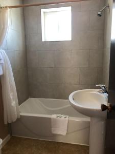 a bathroom with a tub and a sink at Sun Beach Motel in Osoyoos +33 photos