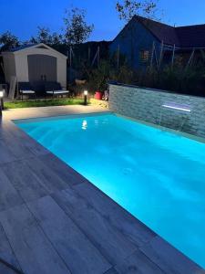 a large blue swimming pool in a yard at Magnifique Villa avec piscine in Corcelles-les-Monts