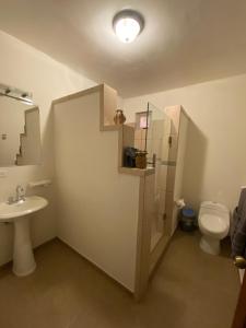un baño con inodoro y lavabo en Loreto Palms Suites, en Loreto