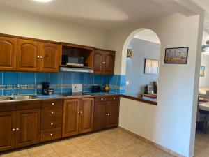 Una cocina grande con gabinetes de madera y fregadero. en Loreto Palms Suites, en Loreto 4 fotos más