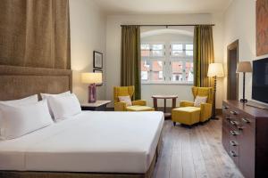 une chambre d'hôtel avec un grand lit et des chaises dans l'établissement Augustine, a Luxury Collection Hotel, Prague, à Prague