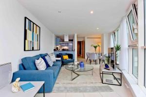 ein Wohnzimmer mit einem blauen Sofa und einem Tisch in der Unterkunft Lovely 2BD flat with River view in London
