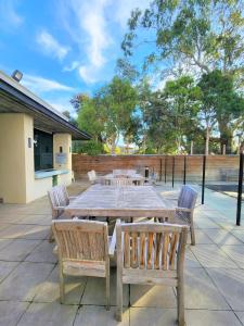 Une table et des chaises en bois sont disponibles sur la terrasse. dans l'établissement Phillip Island Apartments, à Cowes