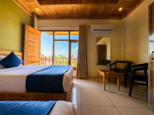 Cette chambre comprend 2 lits et une fenêtre. dans l'établissement Hotel Corbett Bunglow By Food Bunglow, à Rāmnagar