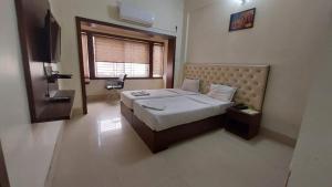 a bedroom with a bed and a television in it at Hotel Tripletree Bhubaneswar in Bhubaneshwar