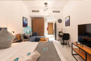 a bedroom with a bed and a living room at Bloomfields Furnished Studio In Oasis in Abu Dhabi