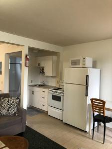 a kitchen with a white refrigerator and a stove at Sun Beach Motel in Osoyoos