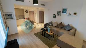 Stylish 1bedroom In Water Edge في أبوظبي: غرفة معيشة مع أريكة وطاولة