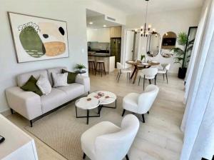 ein Wohnzimmer mit einem Sofa, Stühlen und einem Tisch in der Unterkunft Luxury Golf View Penthouse - Pool+Gym+Beach+Fishing in Punta Cana