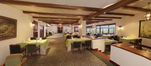 a dining room with green tables and chairs at Estelar Paipa Hotel Spa & Y Centro De Convenciones in Paipa